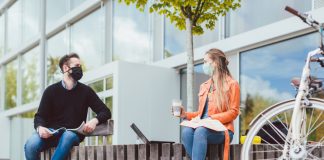 Students on university campus keeping social distance and wearing face masks due to coronavirus