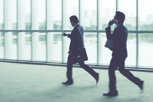 Businesspeople on the phone, rushing through an airport