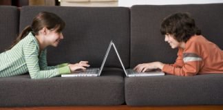 Preteen boy and girl using laptop computers